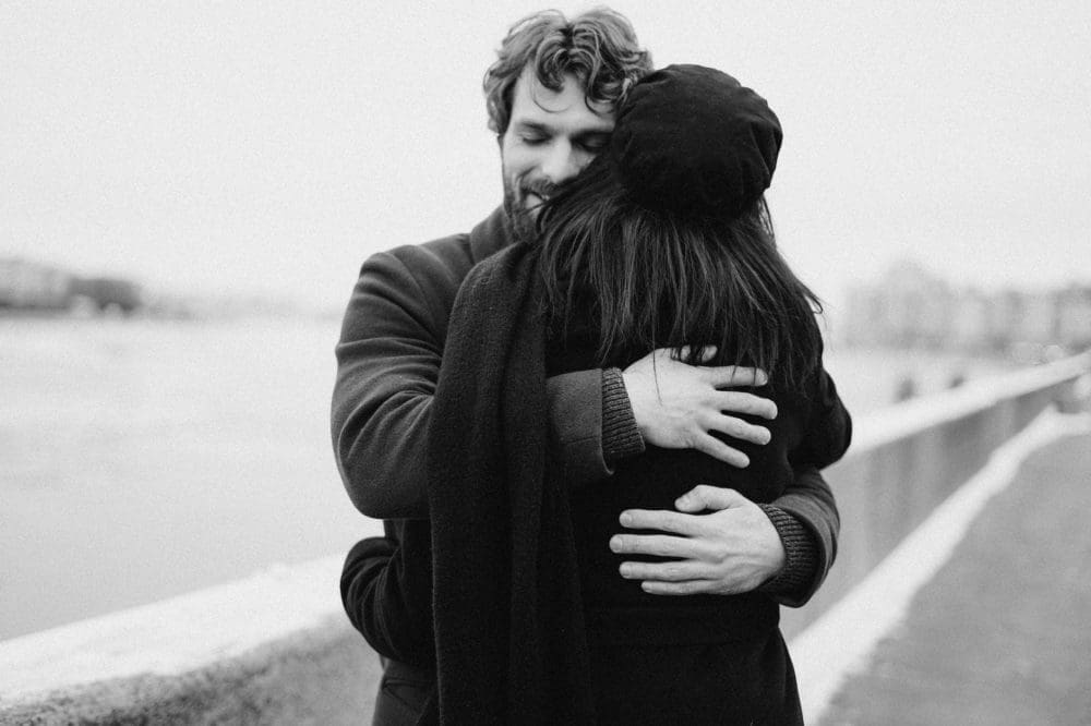 man and woman hugging on bay view