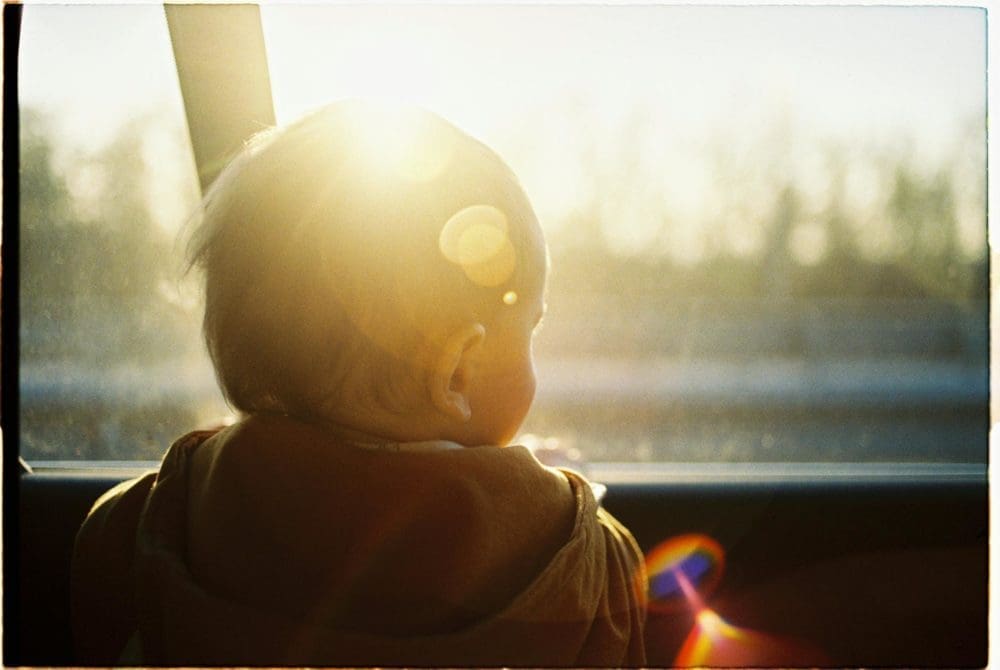 un bébé regarde par la fenêtre d'une voiture