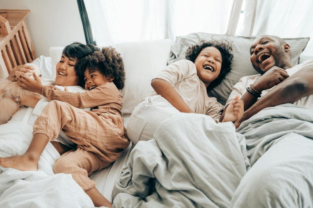 Une famille métissée joue au lit